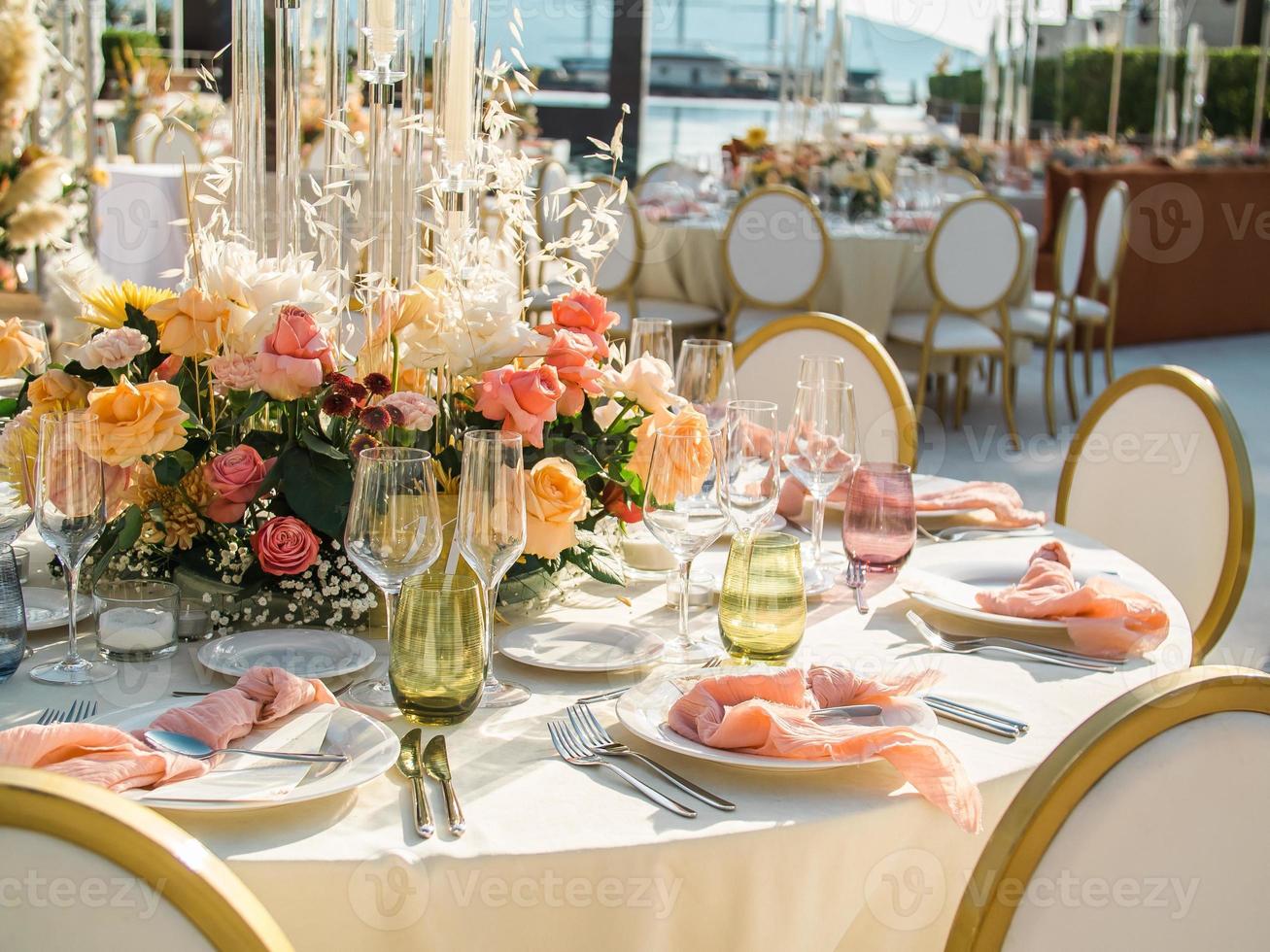 schön draussen Hochzeit Dekoration im Stadt. Kerzen und getrocknet Blumen und Zubehör mit Blumensträuße und Brille auf Tabelle mit Leinen- Tischdecke auf frisch verheiratet Tabelle auf Grün Rasen foto