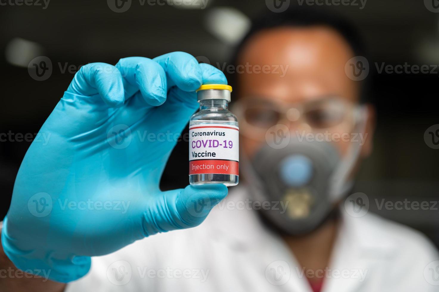 Covid-19-Impfstoffflasche mit Wissenschaftler foto