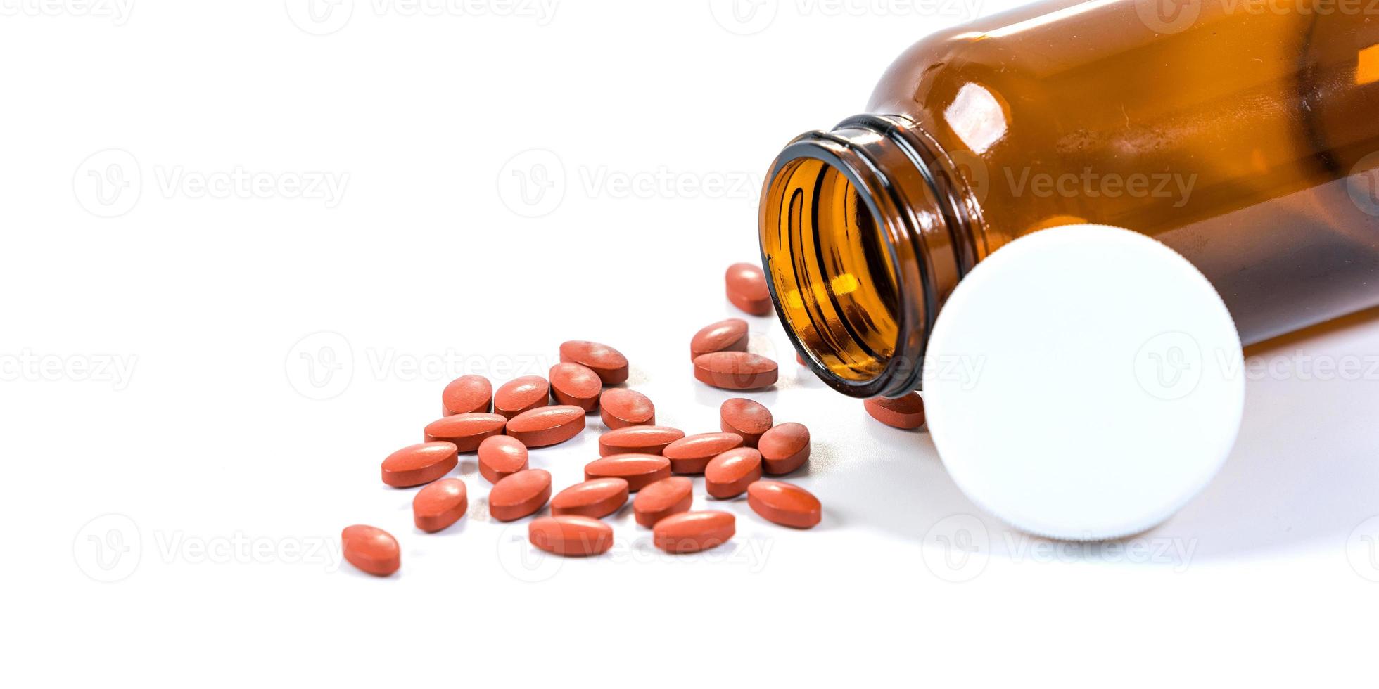 viele Pillen und Medizin, die von der Flasche auf weißem Hintergrund strömen foto