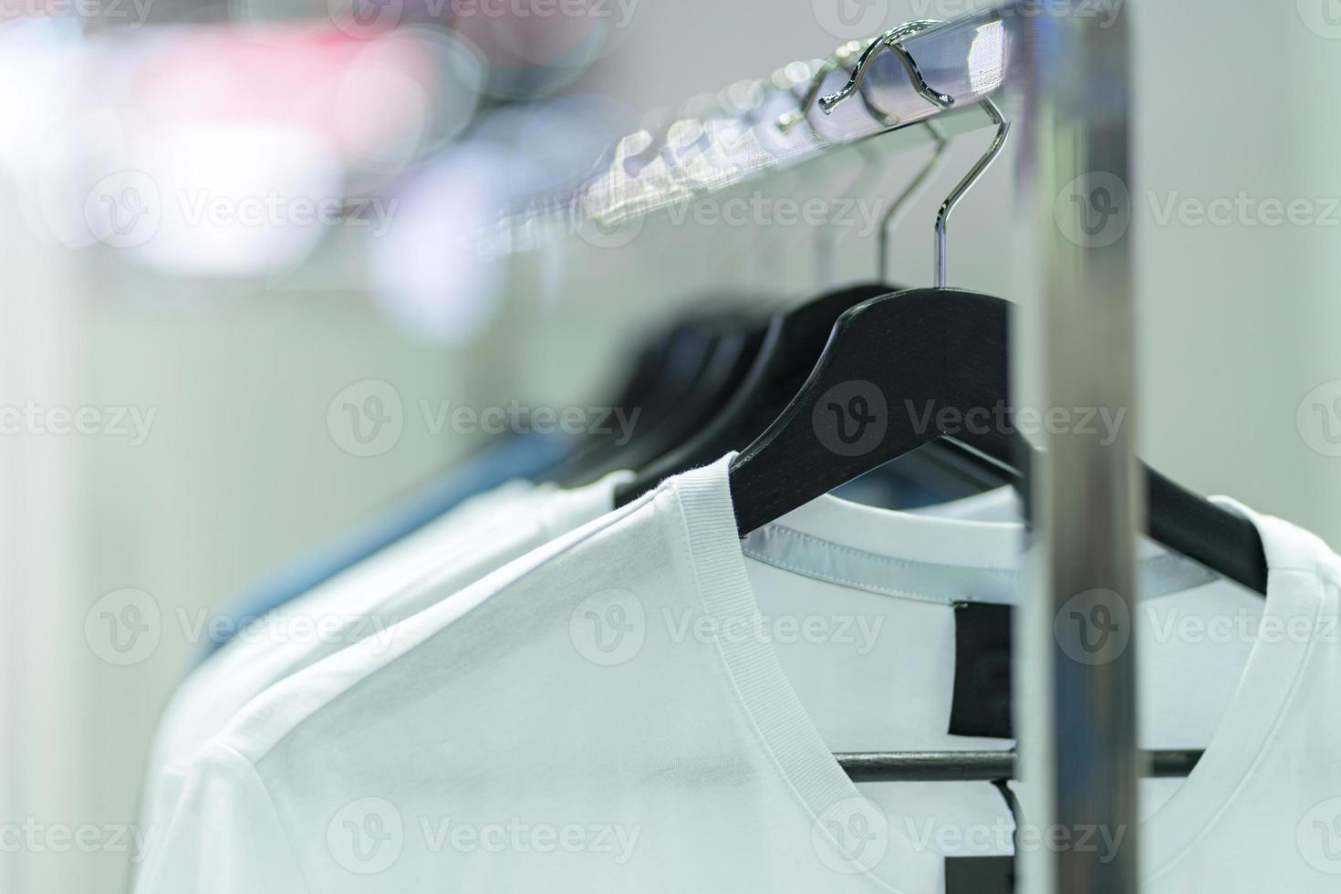 Nahaufnahme von weißen T-Shirts auf Kleiderbügeln, Kleidungshintergrund foto