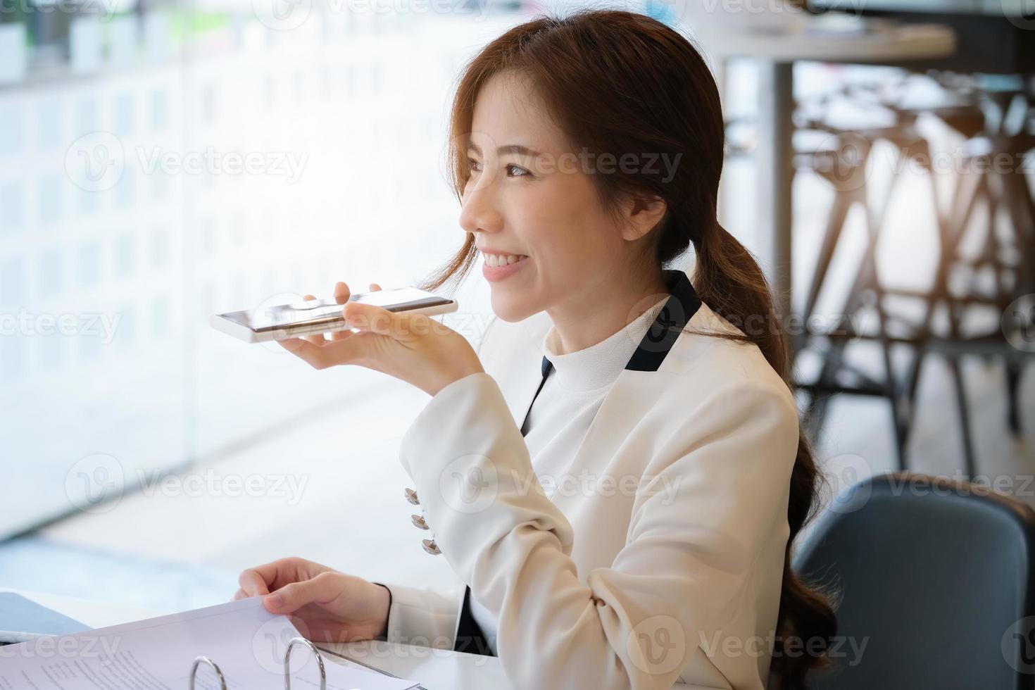 Frau spricht über Freisprecheinrichtung im Büro foto