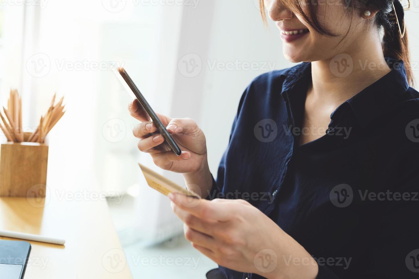 Frau, die am Telefon bezahlt foto