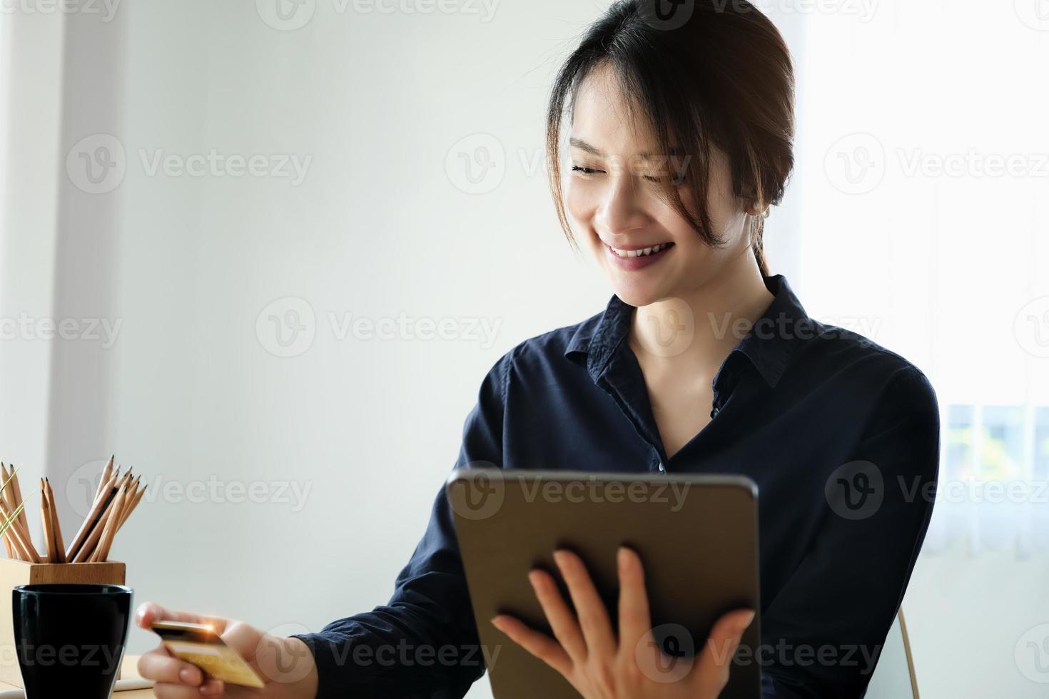 Frau mit Tablet zu bezahlen foto