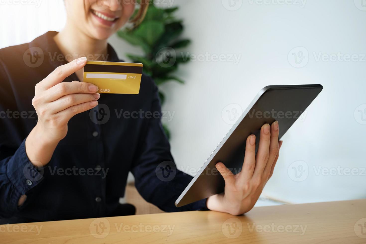 Frau, die eine Tablette und eine Kreditkarte hält foto