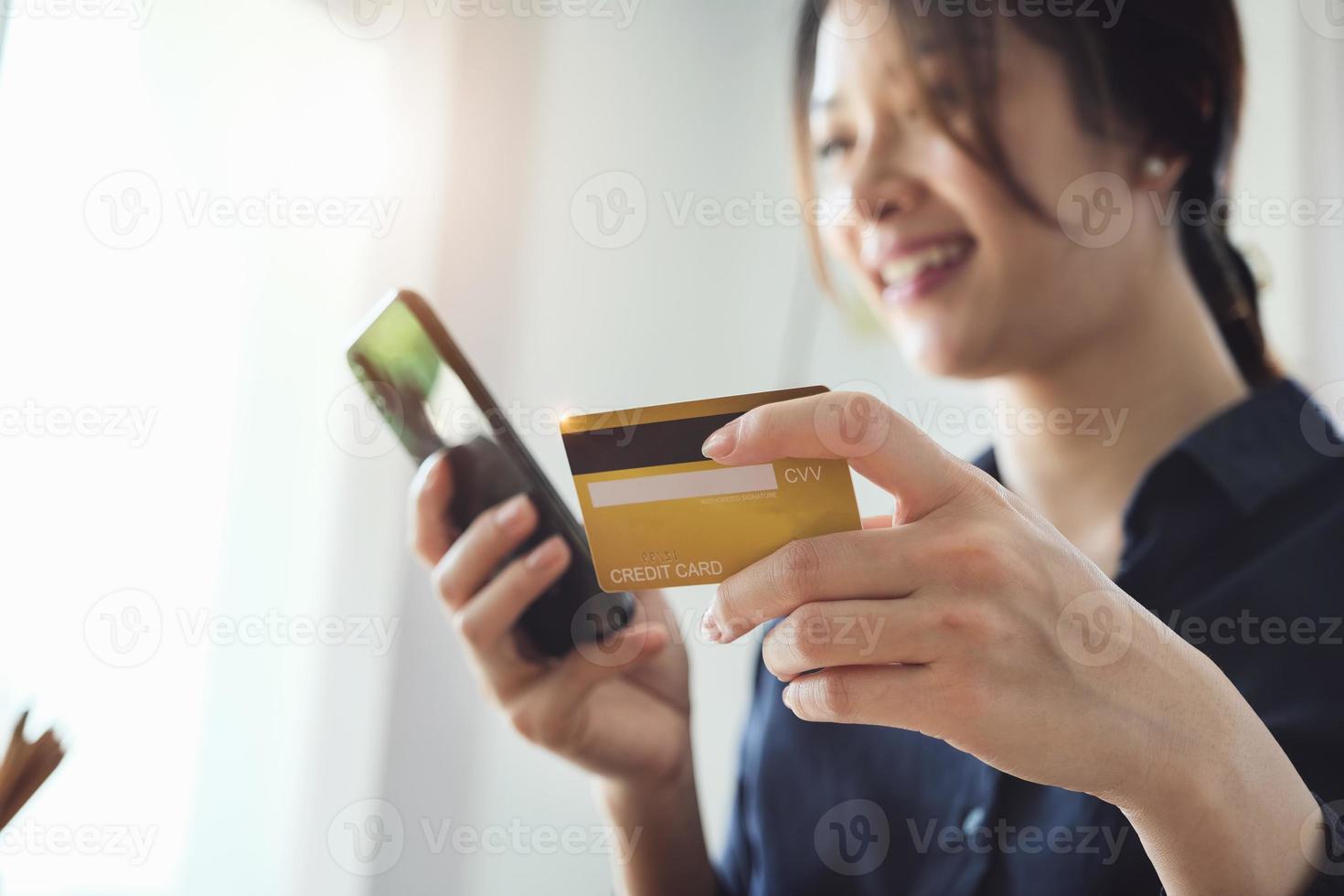 Frau, die Kreditkarteninformationen auf ihrem Telefon eingibt foto