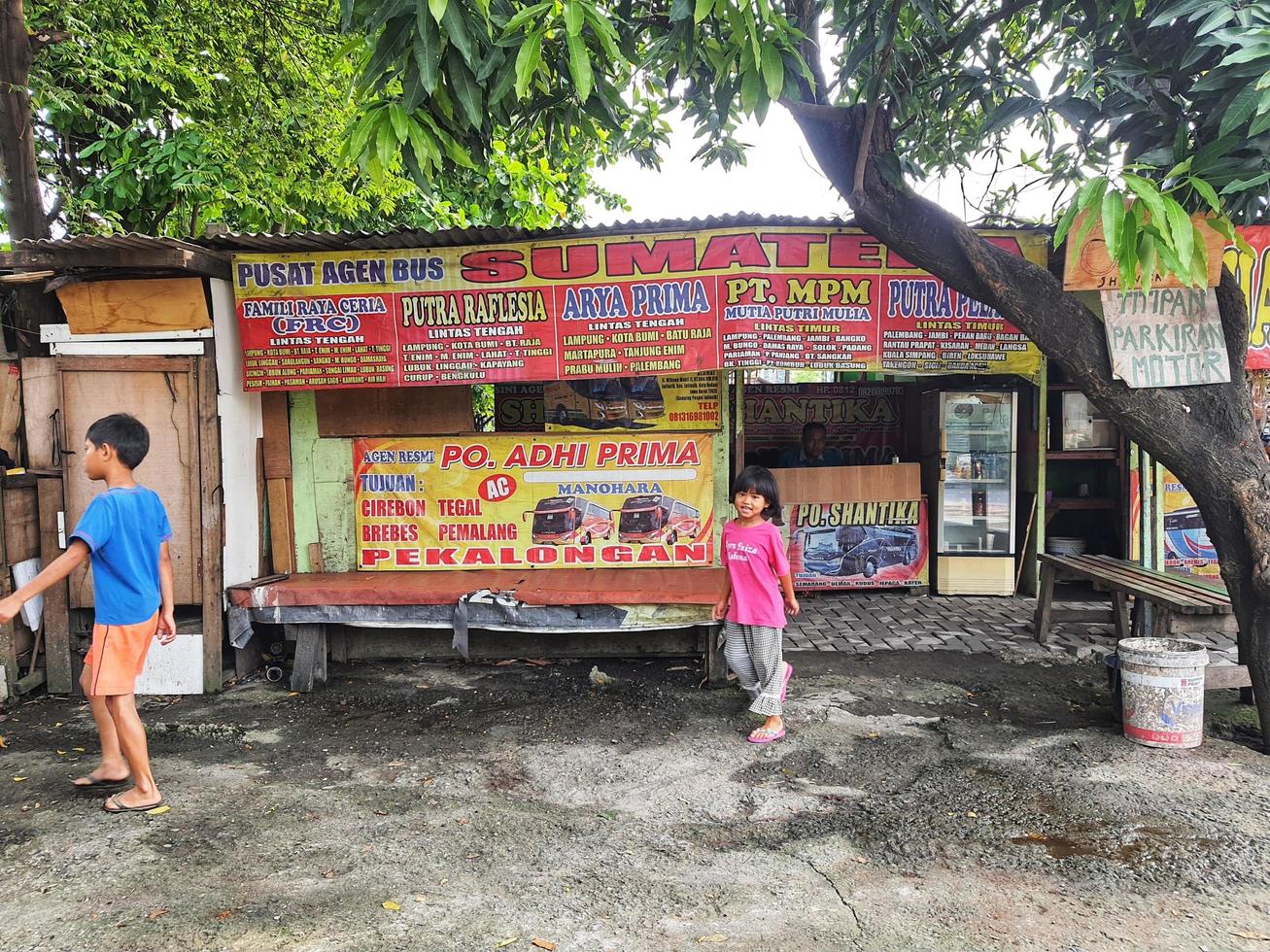 bekasi, Indonesien im November 2022. ein Kind ist Gehen im Vorderseite von ein Bus Fahrkarte Agentur. foto