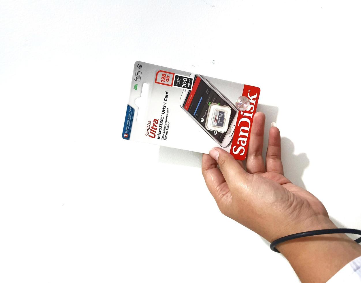 Jakarta, Indonesien im März 2023. isoliert Weiß Foto von ein Hand halten ein Marke Neu Sandisk Ultra Mikro sd Erinnerung Karte
