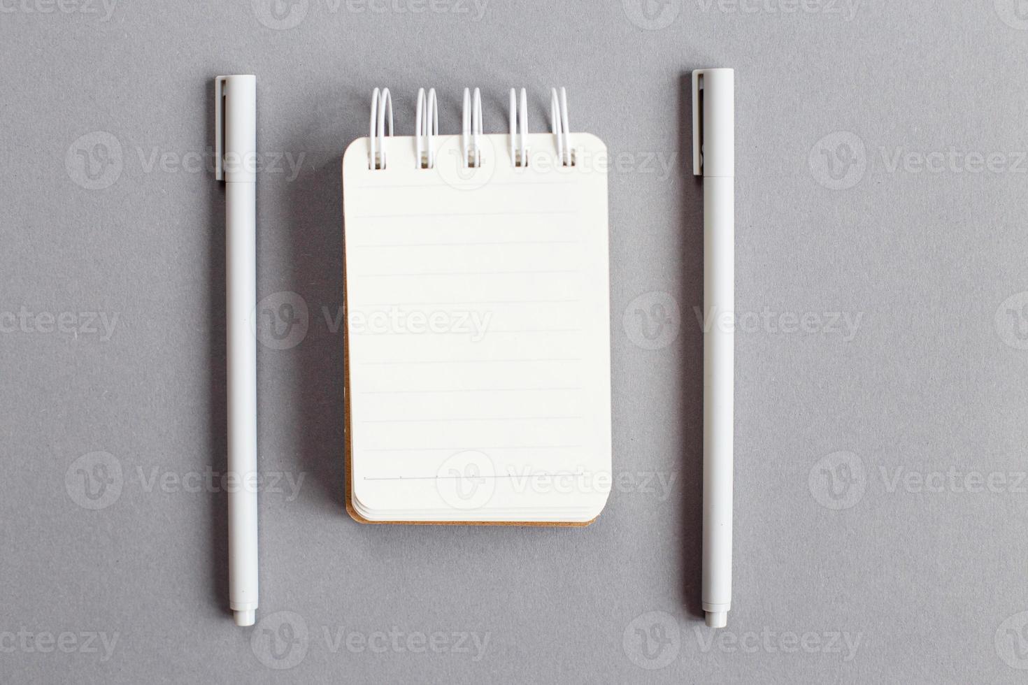 Draufsicht auf leeres Briefpapier mit Stift auf grauem Hintergrund foto