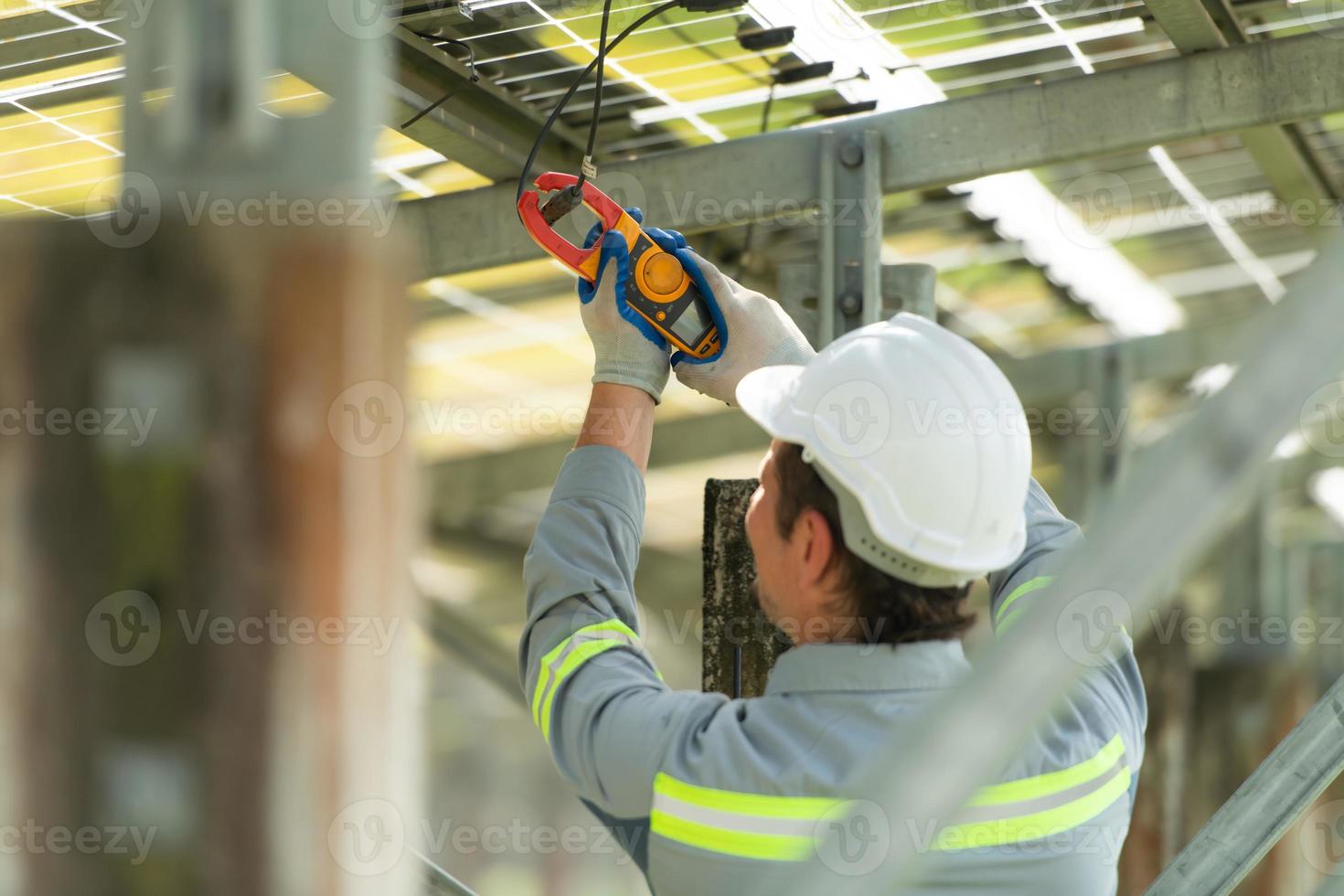 elektrisch Ingenieure ist inspizieren und Aufrechterhaltung Solar- Paneele beim ein Solar- Panel Seite? ˅ im das Mitte von ein hundert Acre Feld. foto