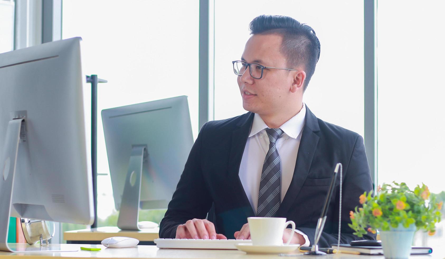 schöner charmanter und selbstbewusster Geschäftsmann, der in einem modernen Büro arbeitet foto