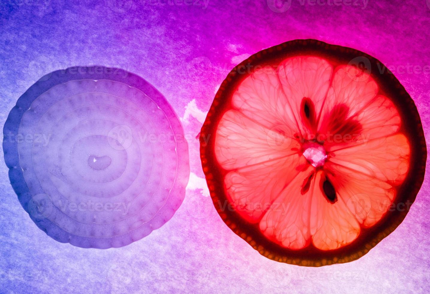 Zwiebel und Zitrone dünne Scheiben Makroaufnahme, bunt beleuchtet und von hinten beleuchtet foto