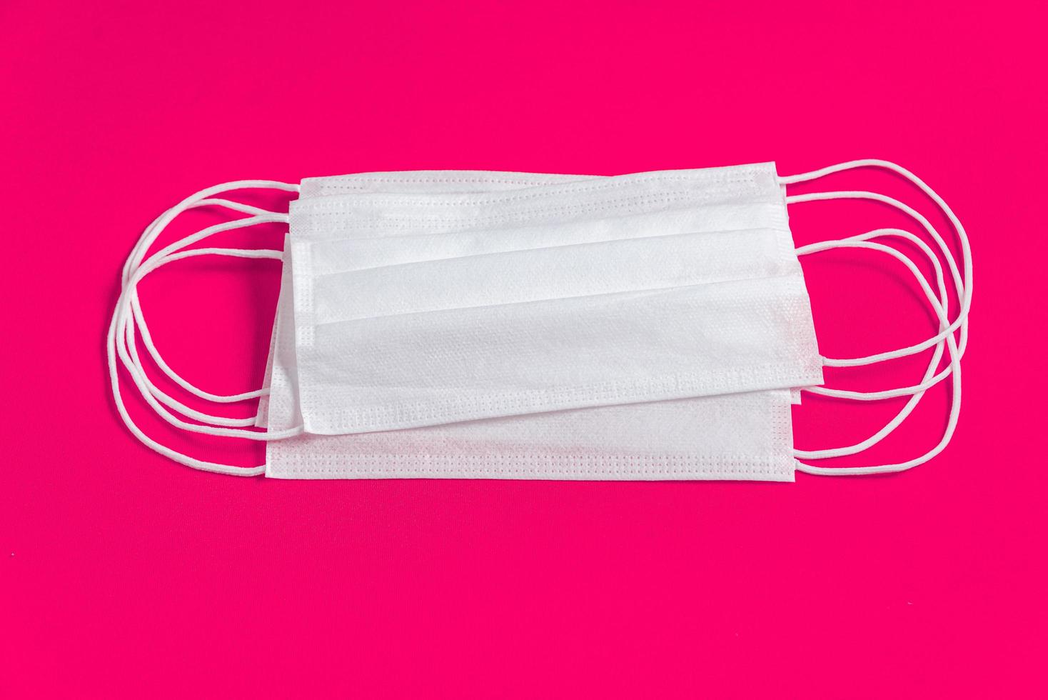 chirurgische Maske über minimalistischem rosa Hintergrund foto