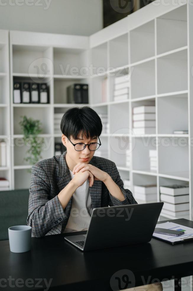 jung Geschäft Mann Exekutive Manager suchen beim Laptop Aufpassen online Webinar Ausbildung oder haben virtuell Treffen Video Konferenz tun Markt Forschung Arbeiten im Büro. foto