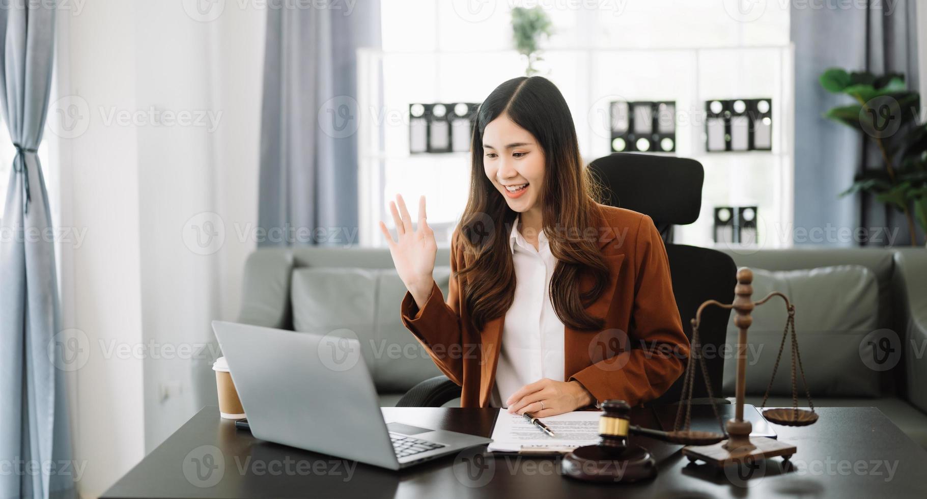 asiatisch weiblich Anwalt chatten online mit Klient auf Laptop, Smartphone diskutieren Einzelheiten von Klage. im modern Büro foto