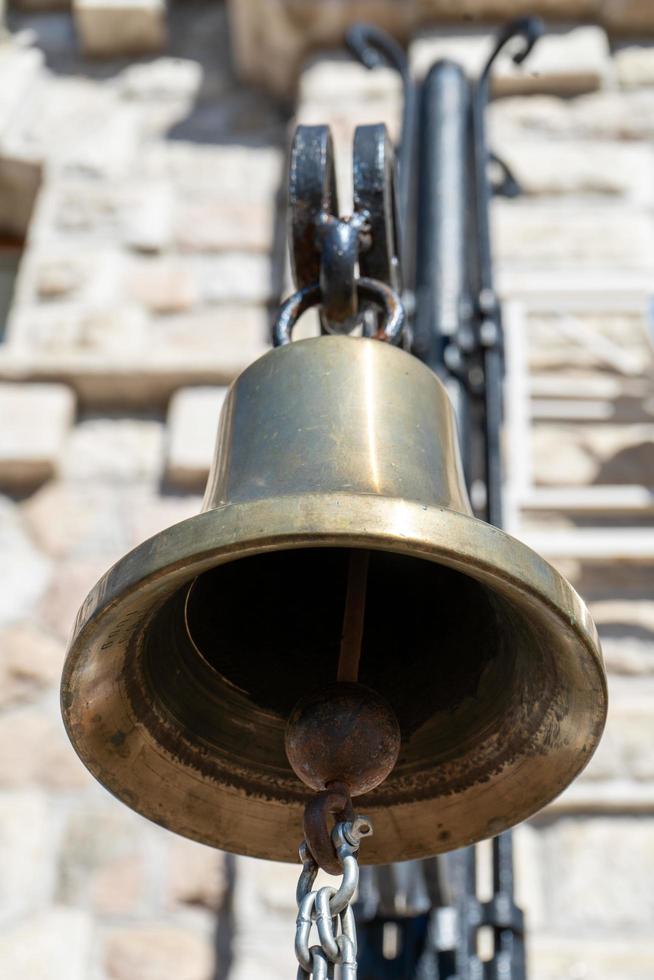 Bronzeglocke Nahaufnahme auf dem Wandhintergrund foto