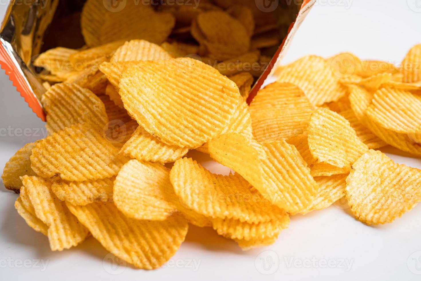 Kartoffelchips, leckeres Grillgewürz würzig für Crips, dünne Scheiben frittierter Snack Fast Food im offenen Beutel. foto