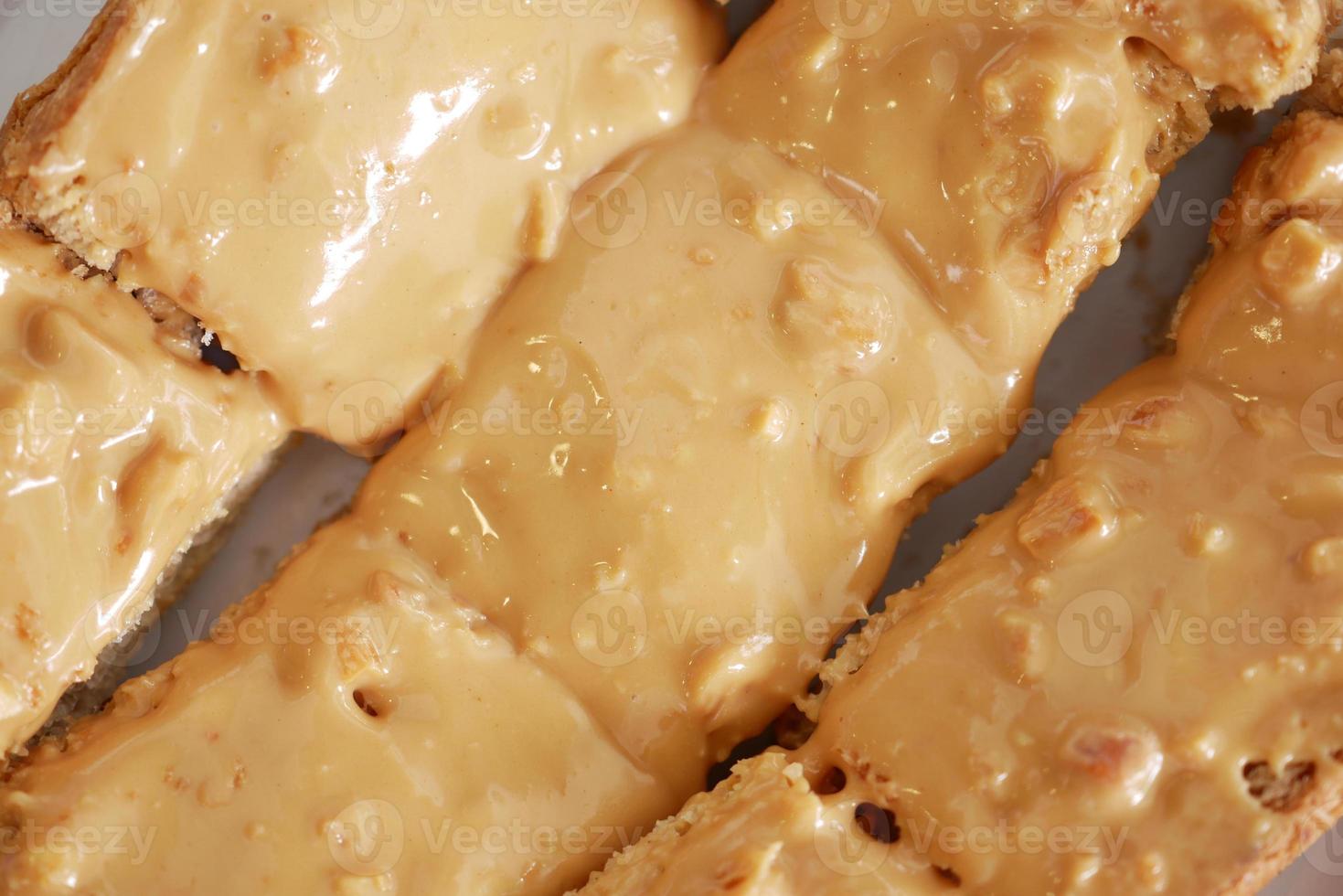 Draufsicht auf Erdnussbutter und ein Brot auf Teller auf schwarzem Hintergrund foto