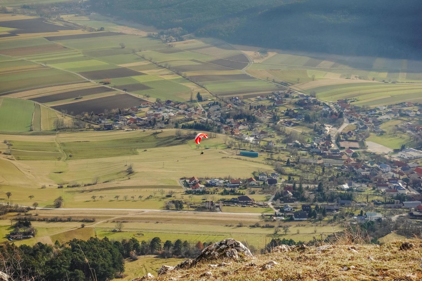 Single bunt Gleitschirm beim ein Berg im ein Grün Senke foto