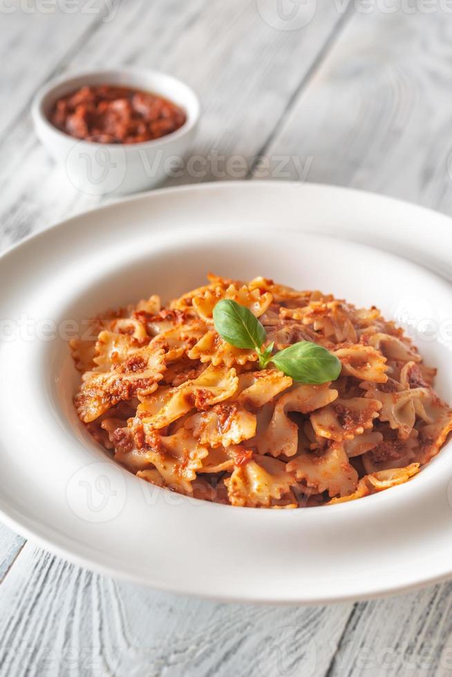 Portion Farfalle mit Pesto aus sonnengetrockneten Tomaten foto