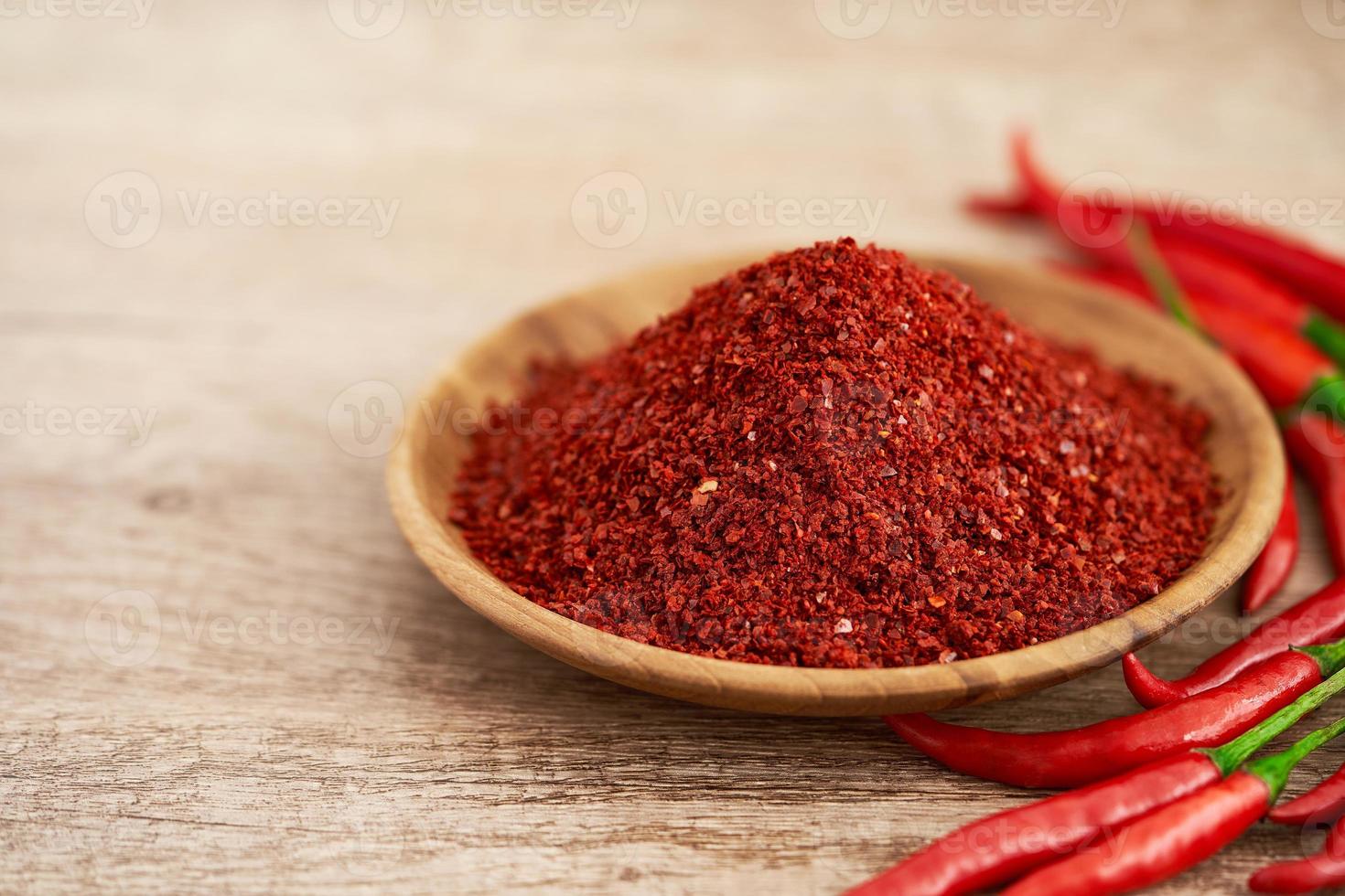 rot Chili Pfeffer Flocke oder Boden Pulver grob im Holz Schüssel auf hölzern Tabelle Essen Hintergrund. rot Chili Pfeffer Flocke oder Boden Pulver grob Lebensmittel. rot Chili Pfeffer Flocke oder Boden Pulver grob foto