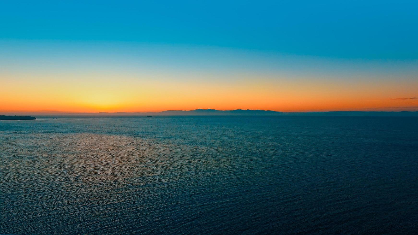 Seelandschaft mit orangefarbenem Sonnenuntergang über dem Horizont. foto