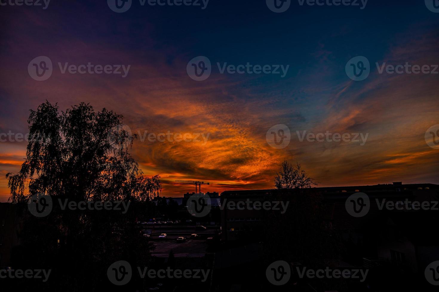 natürlich dramatisch mit Wolken bunt städtisch Sonnenuntergang mit Konstruktion Kran foto