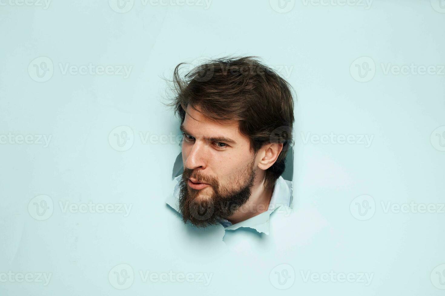 ein bärtig Mann guckt aus von hinter das Mauer Unzufriedenheit Emotionen Büro offiziell foto