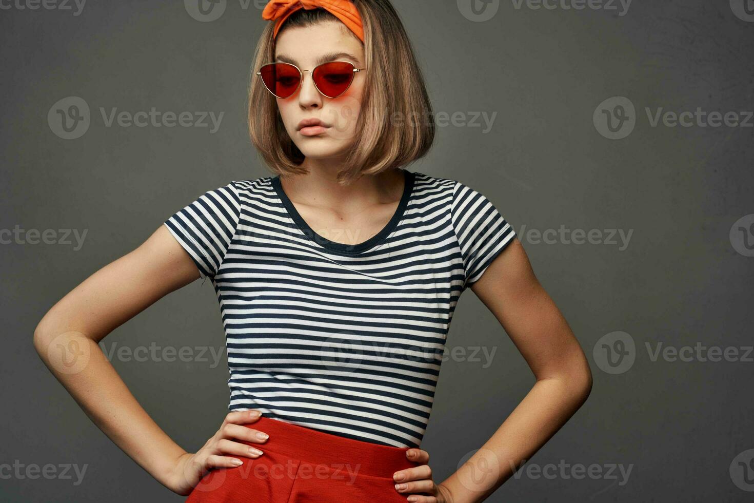 Frau mit Orange Binde auf ihr Kopf tragen Sonnenbrille posieren Mode Luxus foto