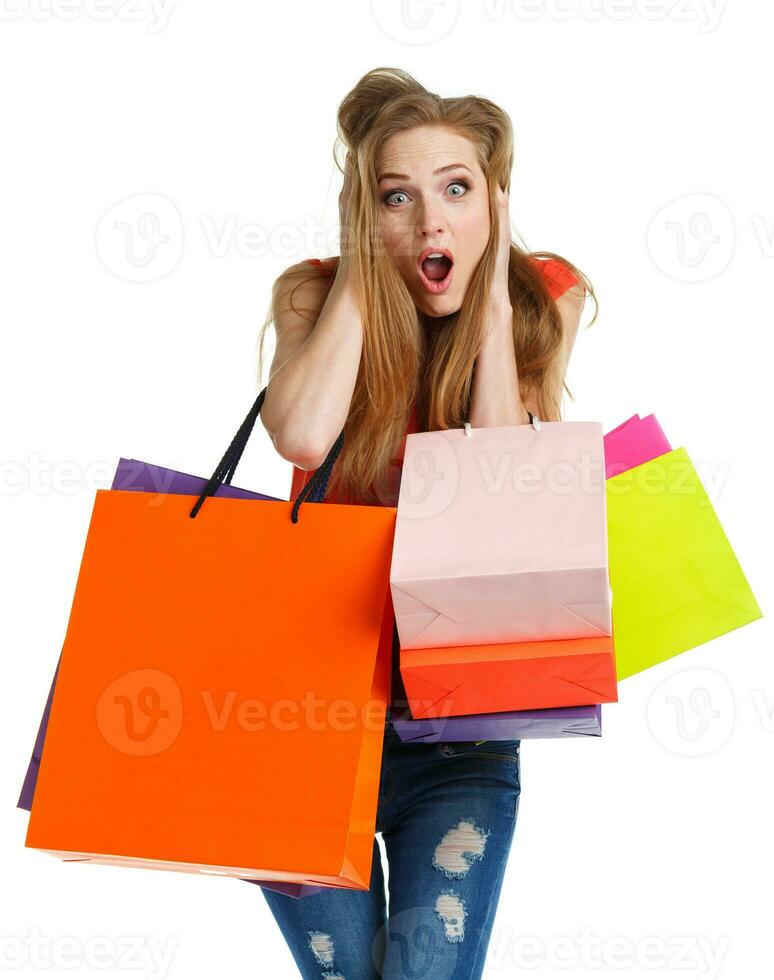 jung kaukasisch Frau halten Einkaufen Taschen auf Weiß Hintergrund ist schockiert foto