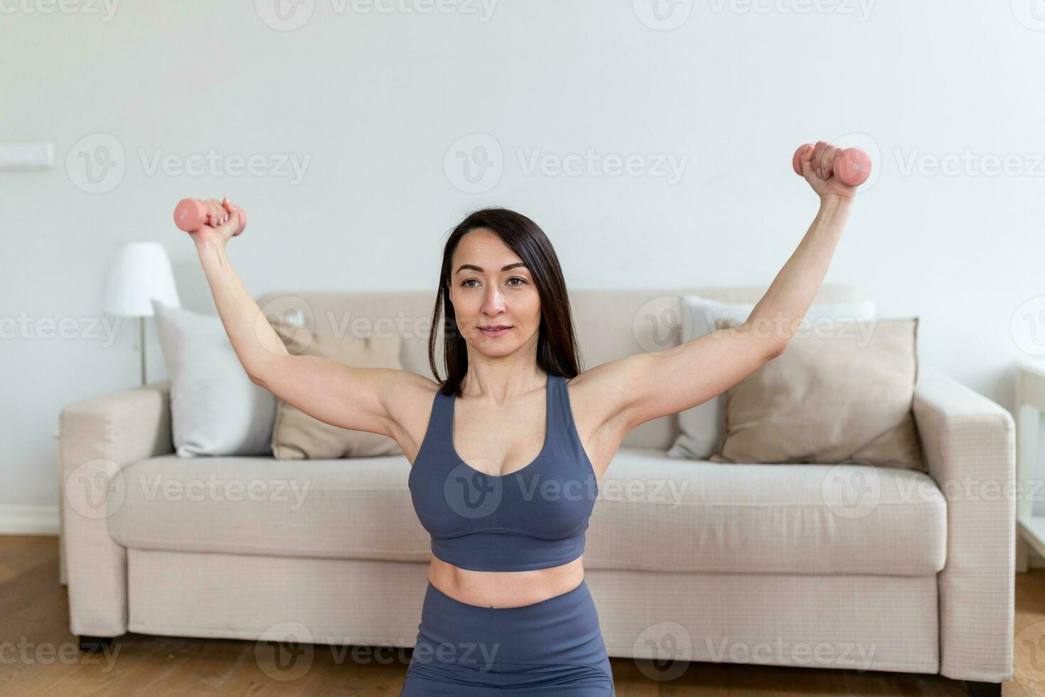 asiatisch Frau Übung mit Hanteln beim heim. glücklich weiblich tun Arm trainieren mit Hanteln foto