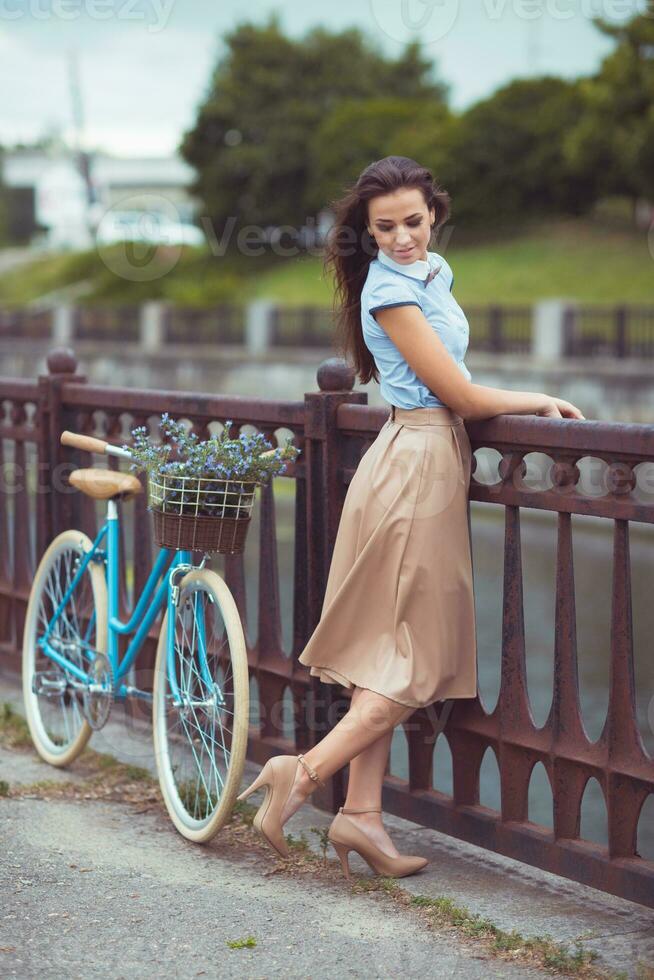 jung Schön, elegant gekleidet Frau mit Fahrrad draussen foto