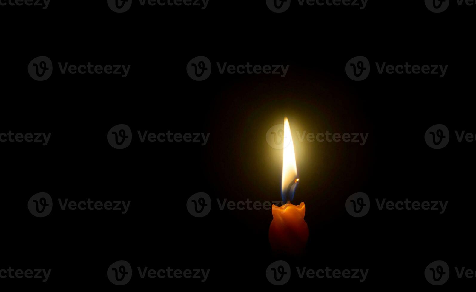 ein Single Verbrennung Kerze Flamme oder Licht glühend auf Spiral- Orange Kerze auf schwarz oder dunkel Hintergrund auf Tabelle im Kirche zum Weihnachten, Beerdigung oder Denkmal Bedienung mit Kopieren Raum foto