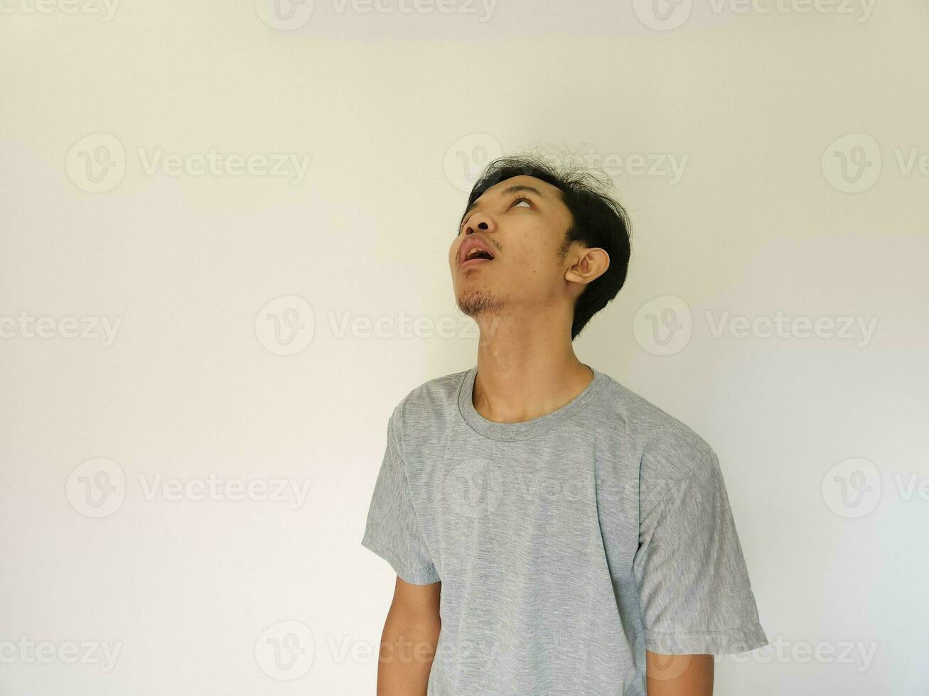 asiatisch Mann fühlt sich gelangweilt und gegenüber oben mit isoliert Hintergrund foto