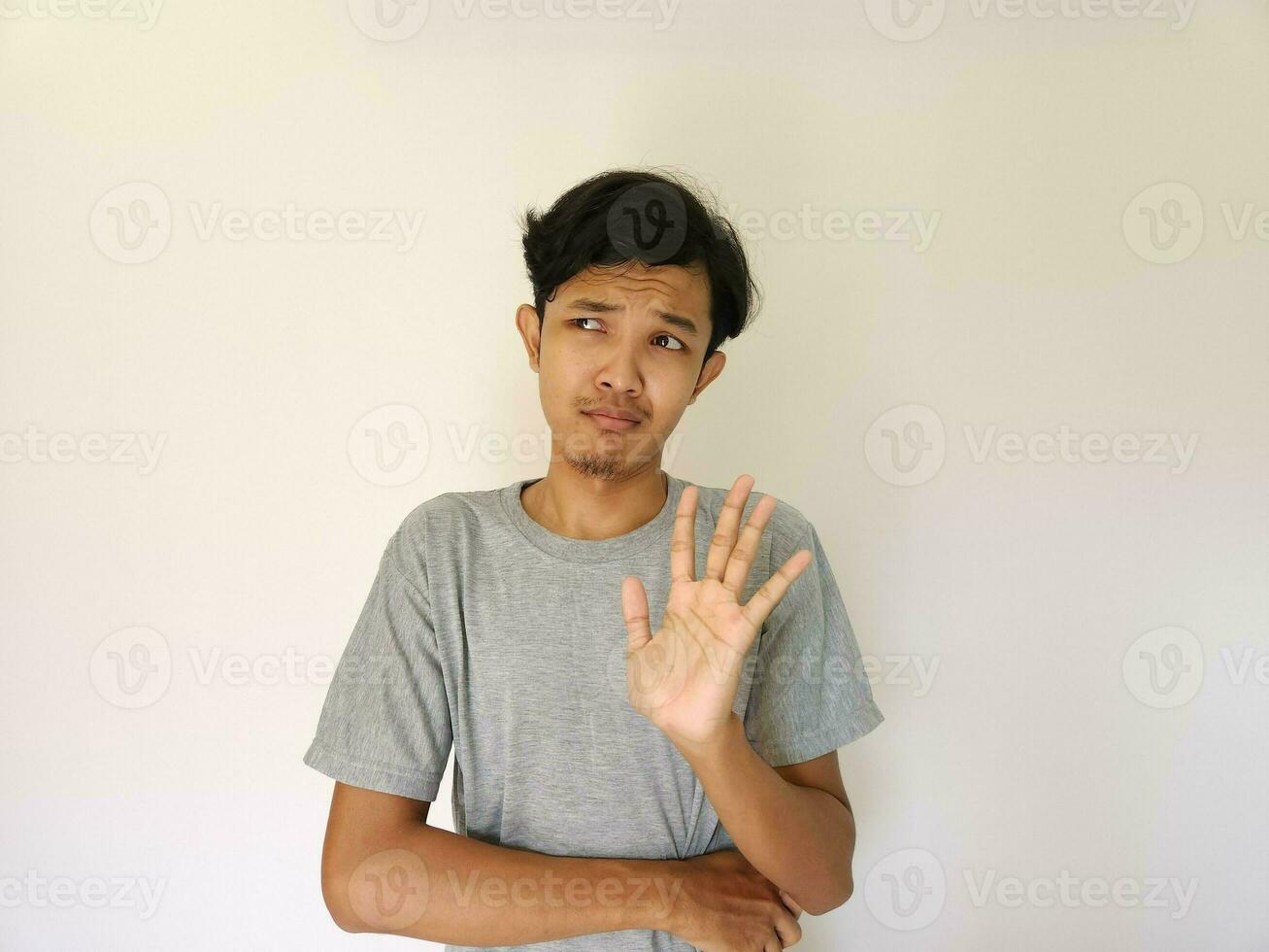 asiatisch Mann zeigen Ablehnung Zeichen, Sprichwort NEIN, stoppen. isoliert auf Weiß foto