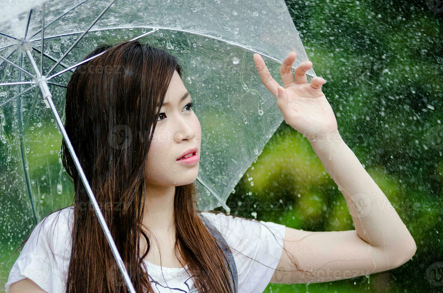 schön Mädchen ist Stehen mit Regenschirm unter ein Regen 3 foto