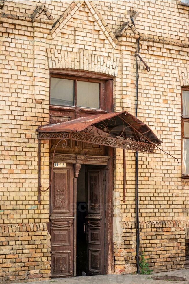 ein alt hölzern Tür mit ein Visier im ein Stadt Haus. foto
