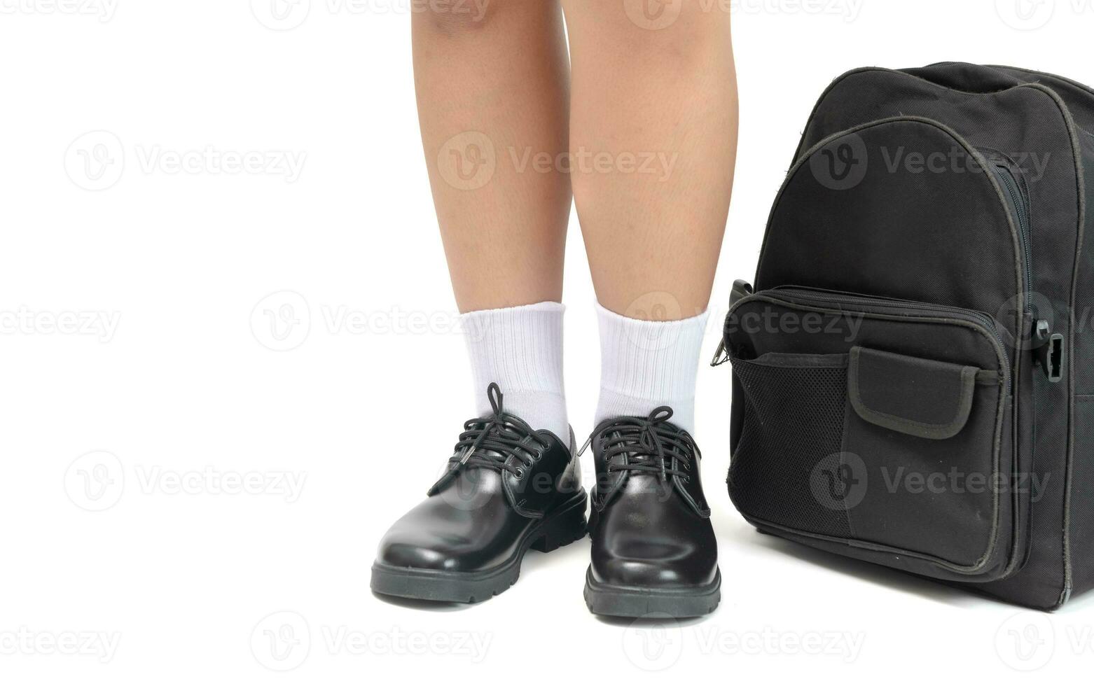 Schüler tragen ein schwarz Leder Schuhe und Schule Tasche. foto