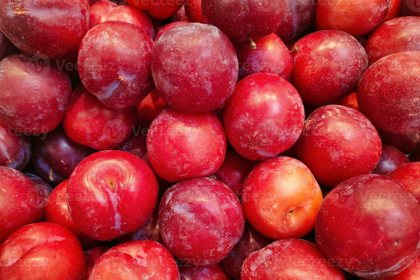 Stapel rote Pflaumen auf einem Marktstand foto