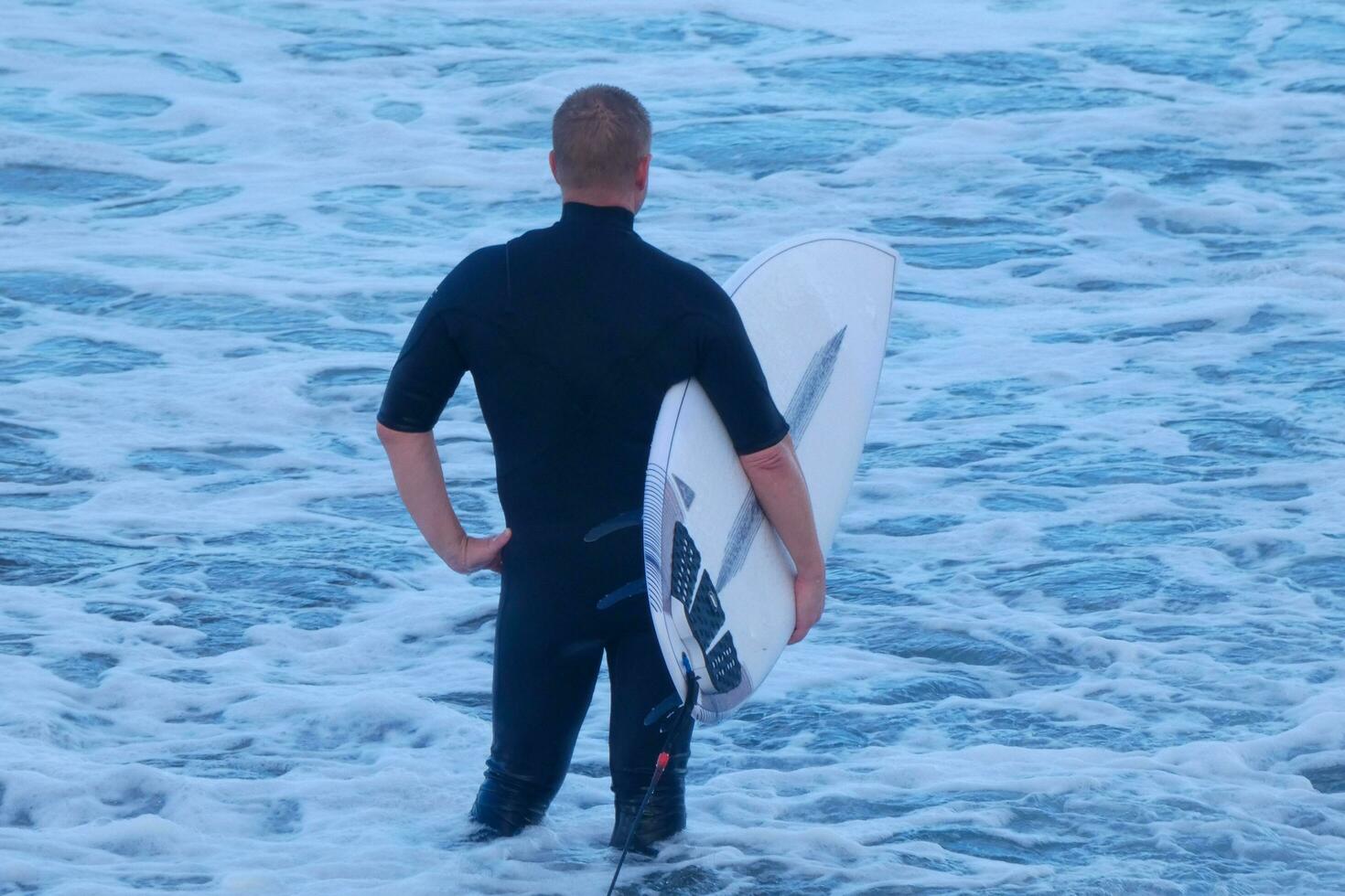 Surfer bekommen bereit zu eingeben das Wasser und Gehen mit das Tafel entlang das Ufer. foto