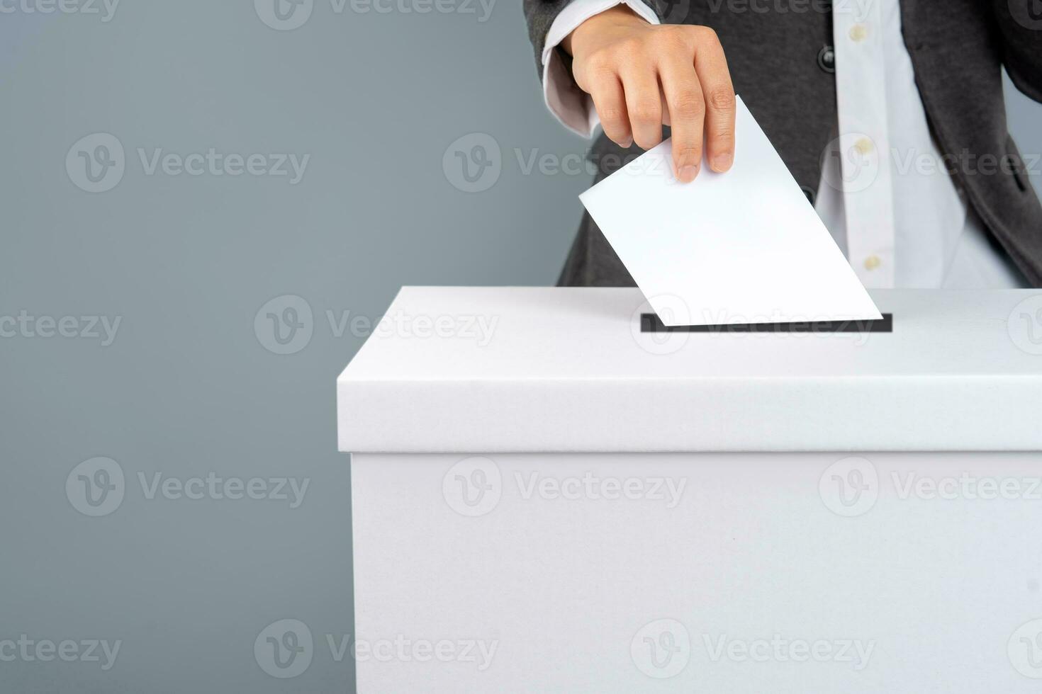 ein Wähler hält Abstimmung Abstimmung Papier im das Abstimmung Kasten. Wahl Konzept. foto