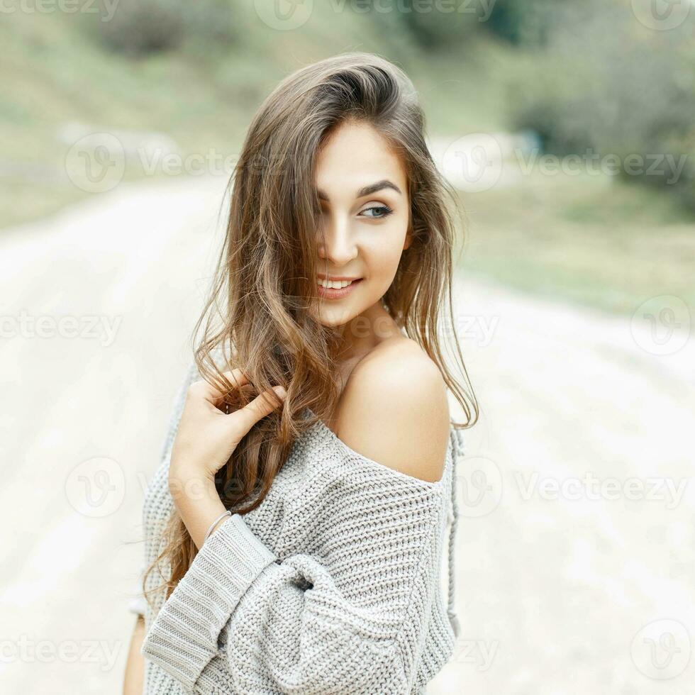 schön jung Mädchen lächelnd mit lockig Frisur im Jahrgang Sweatshirt foto