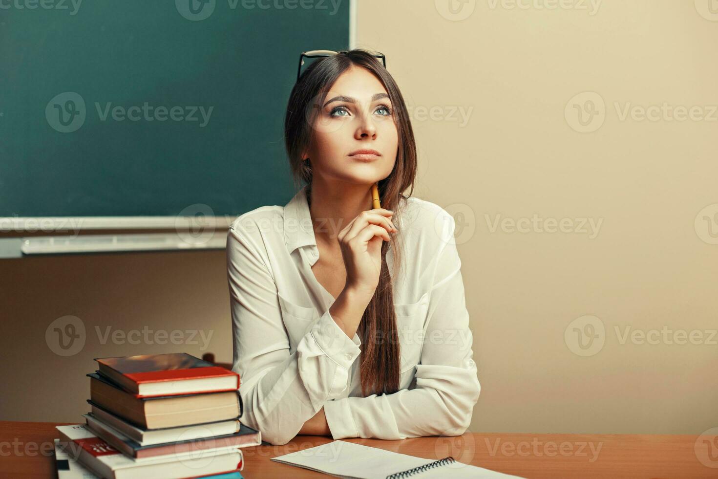 schön jung Frau Sitzung beim das Tabelle mit Bücher und Denken. zurück zu Schule. foto