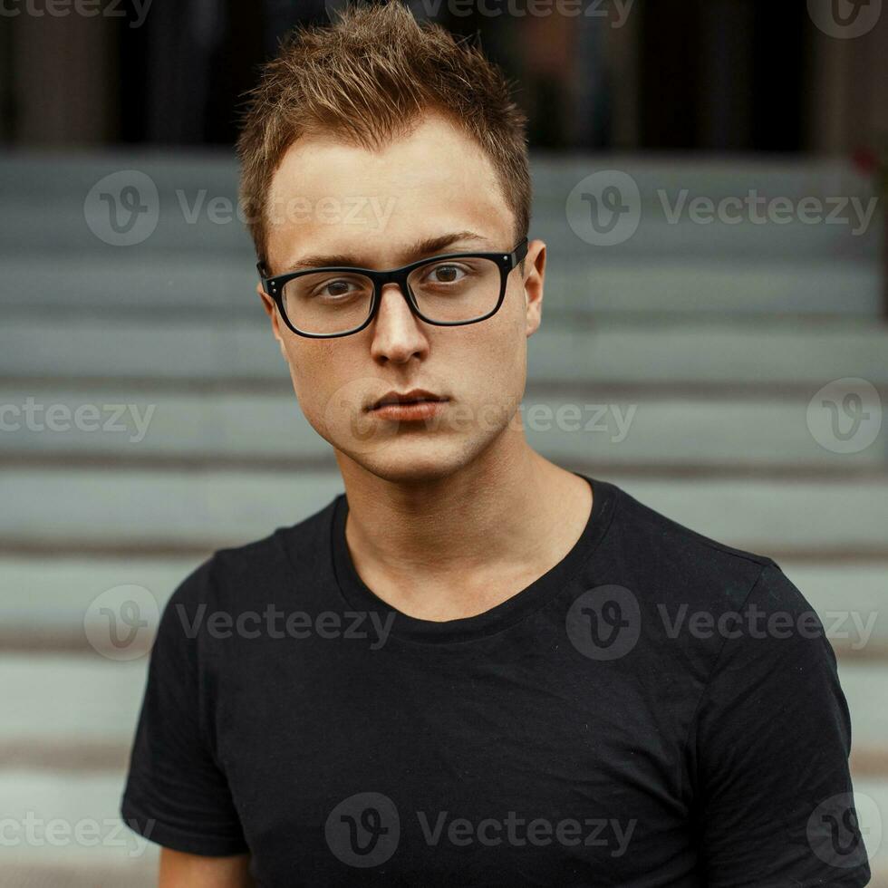 jung gut aussehend Mann mit Brille im ein schwarz Shirt. foto