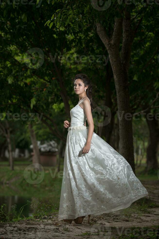 asiatisch Mädchen im Hochzeit Kleid im das Wald foto