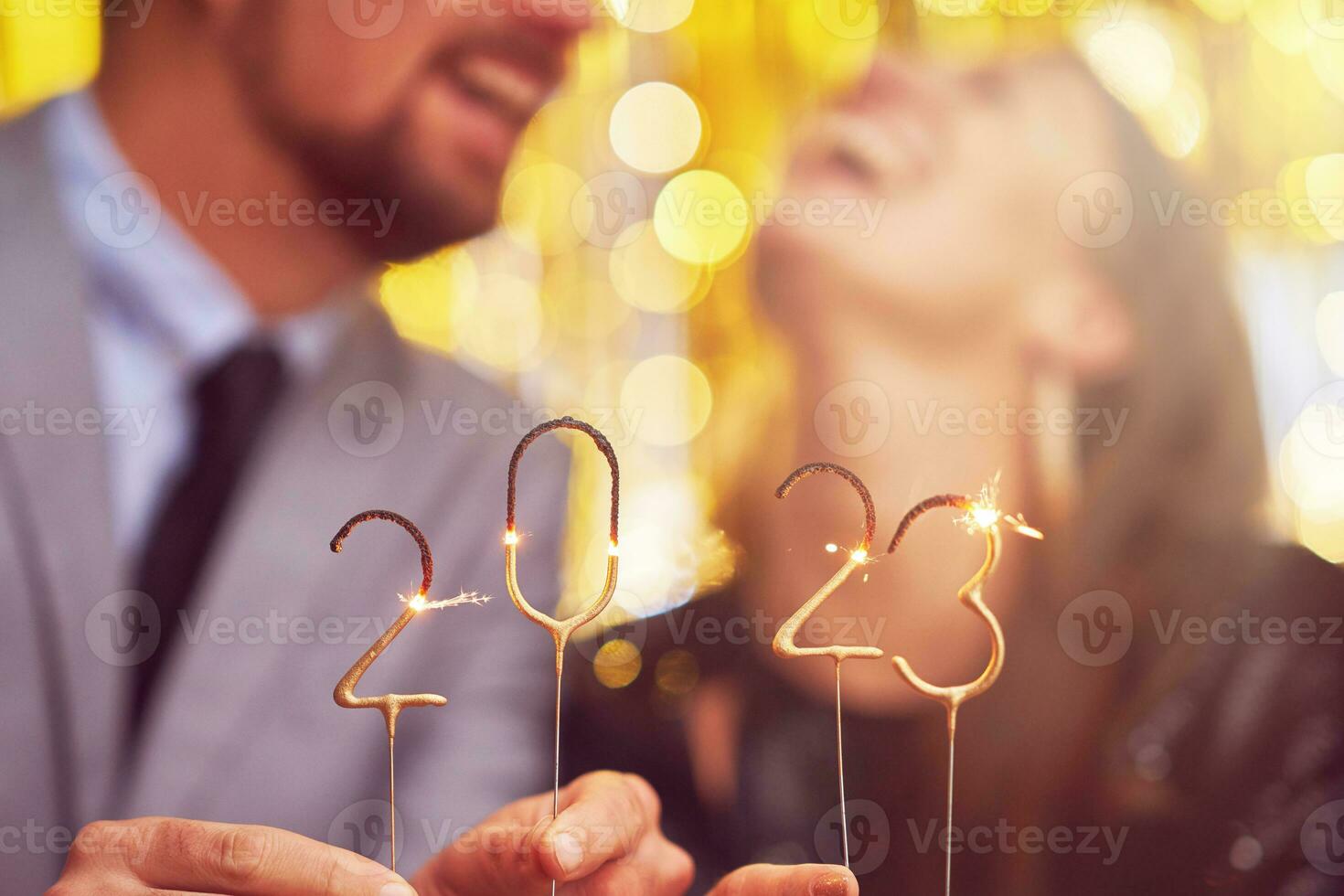 Paar beim Neu Jahr Vorabend Party mit 2023 Wunderkerzen foto