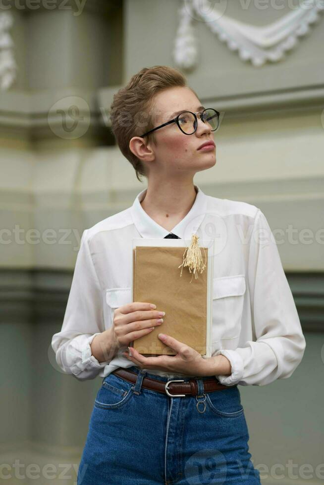 Schüler mit Brille Gehen um das Stadt mit ein Buch Bildung foto