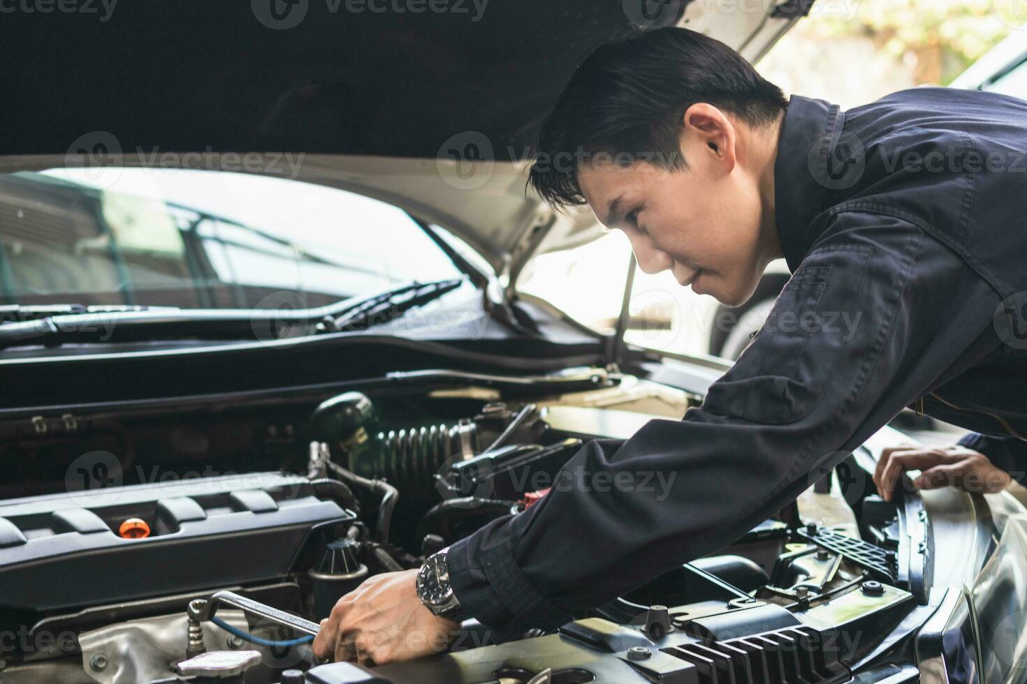 Auto Mechaniker Arbeiten im Garage, Techniker Mann Arbeiten im Auto Service, Mechaniker Handwerker mit ein Schlüssel reparieren ein Auto Motor, Auto Reparatur, und Instandhaltung foto
