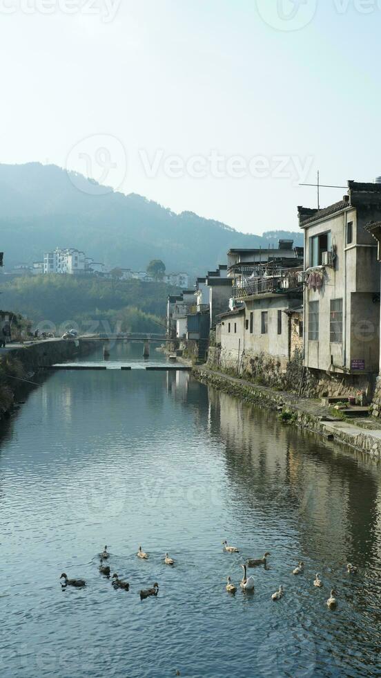 einer alt traditionell Chinesisch Dorf Aussicht mit das alt gewölbt Stein Brücke und alt hölzern Gebäude im das Süd- Landschaft von das China foto