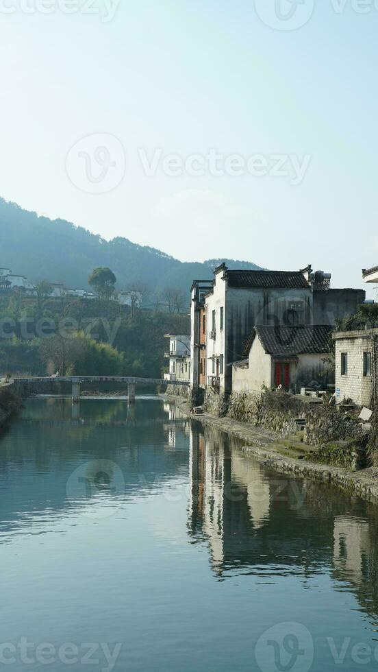 einer alt traditionell Chinesisch Dorf Aussicht mit das alt gewölbt Stein Brücke und alt hölzern Gebäude im das Süd- Landschaft von das China foto