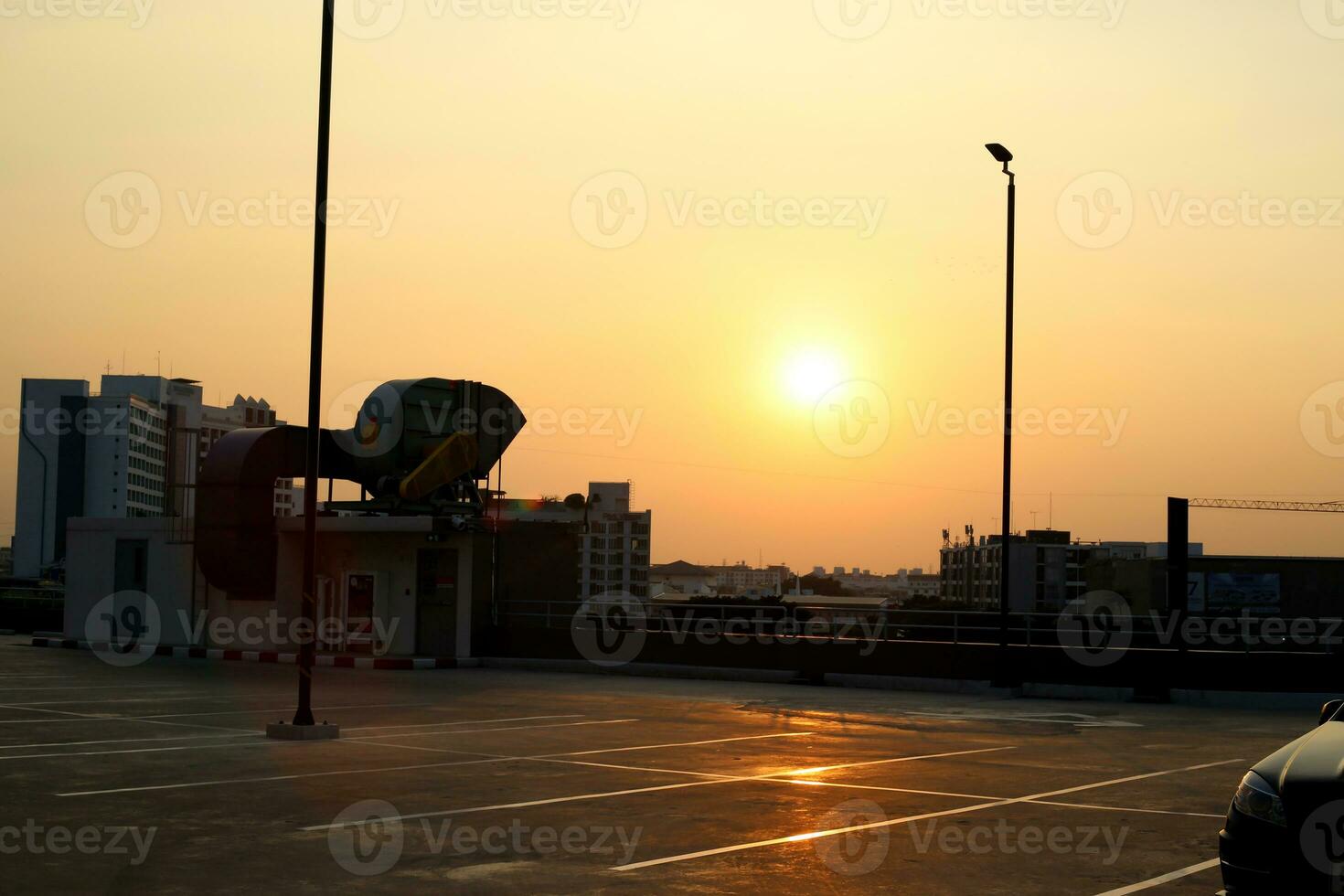 Sonnenuntergang Himmel Parkplatz Menge auf Dach Fußboden mit Licht Pole foto